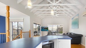 Une cuisine moderne avec un plan de travail bleu, des meubles blancs et un four à micro-ondes encastré.
