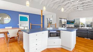 A modern kitchen with white cabinetry, a blue countertop, and a built-in microwave.