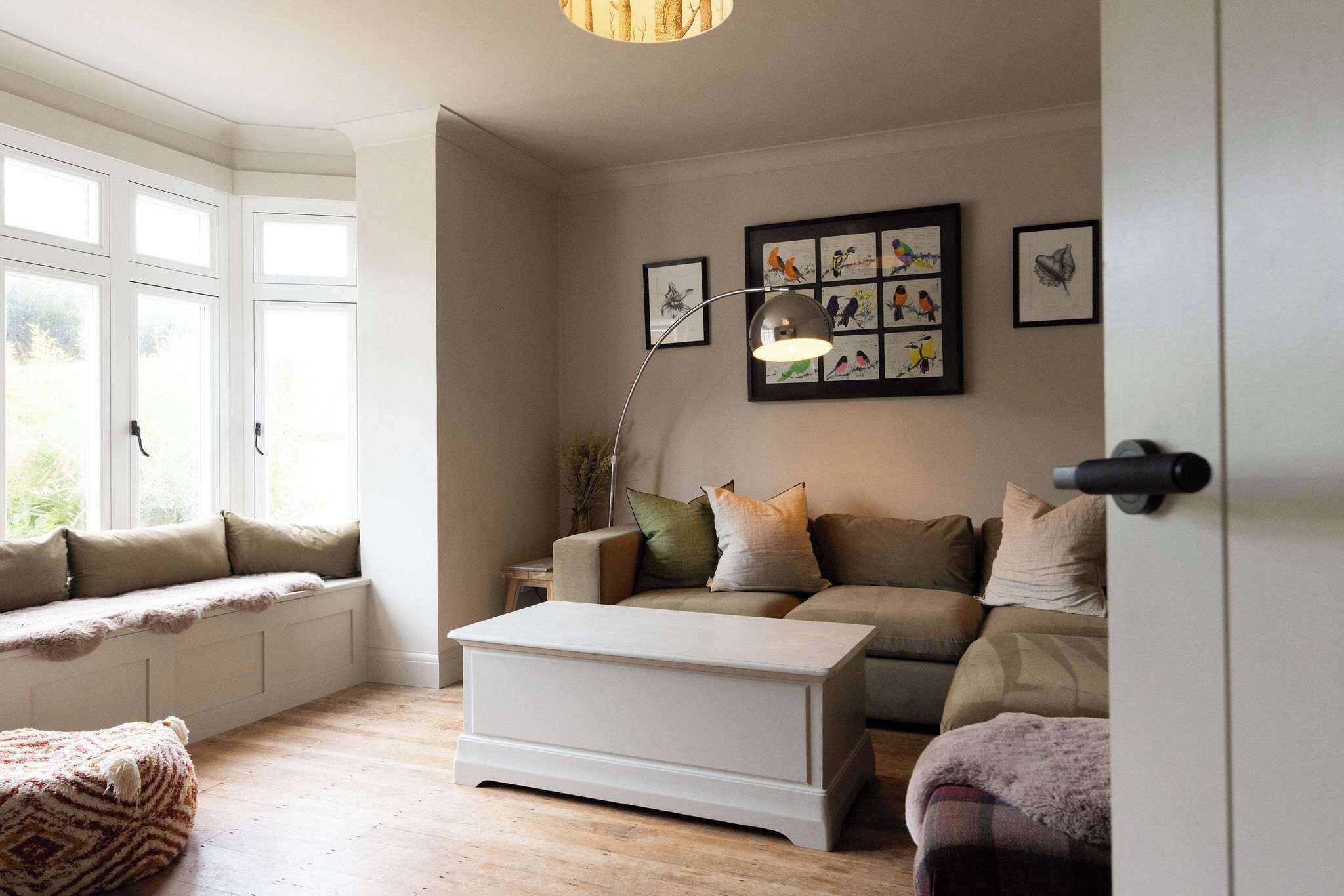 A living room with a sofa set, a coffee table, and a window seat.