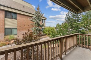 A brick building with a covered porch and a wooden railing. - Powder Pad Park Ave | Ski, Après & Downtown Fun (Park City)