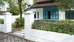 Una casa tradicional con techo de tejas, puertas verdes y paredes blancas.