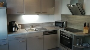 A modern kitchen with stainless steel appliances, a dishwasher, an oven, and a microwave. - Apartment with 2 Bedrooms, Sleeps up to 4 Guests (Olsberg)