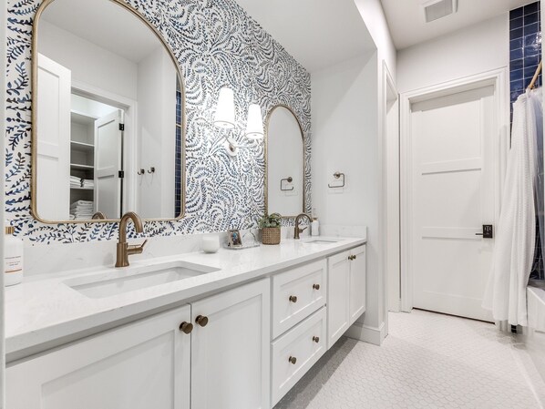 A bathroom with two sinks, a large mirror, and a white cabinet with drawers. - Carlton Landing-The Winston House (Carlton Landing)