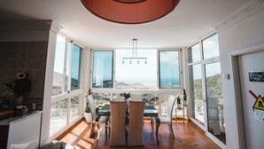 Un comedor con vistas al paisaje a través de amplios ventanales.