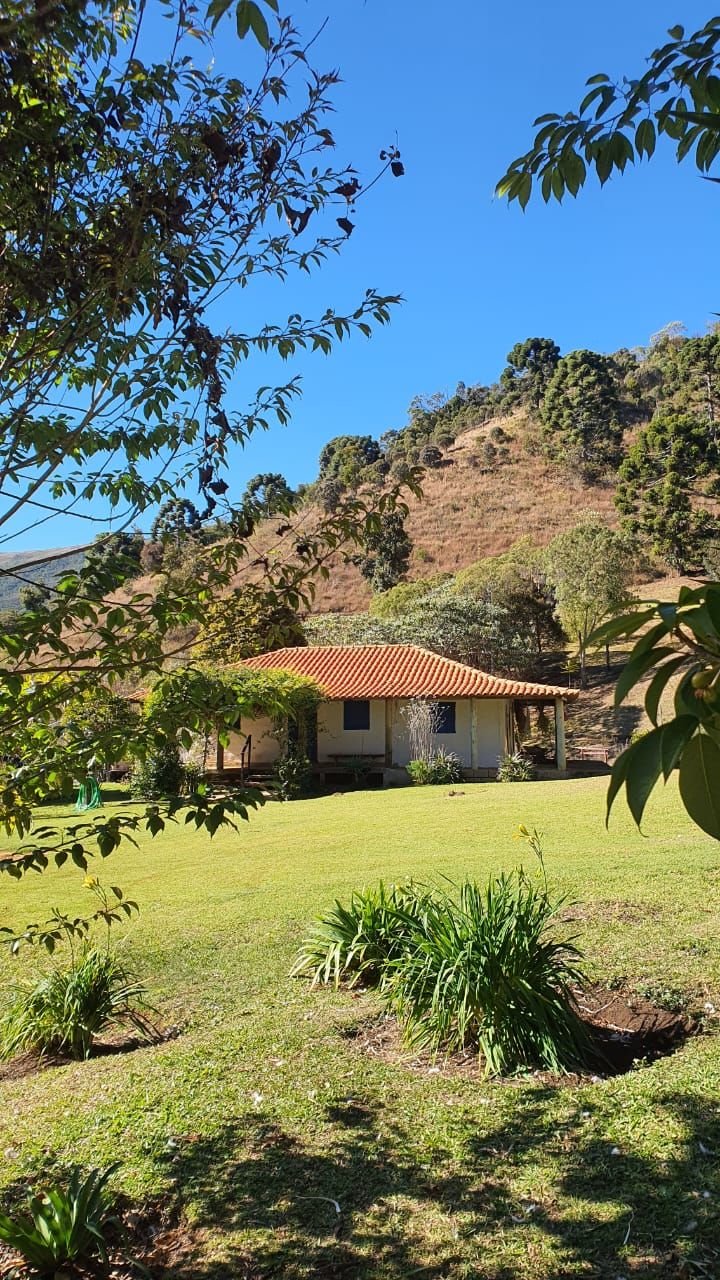 A house with a red roof, surrounded by a grassy yard and trees.