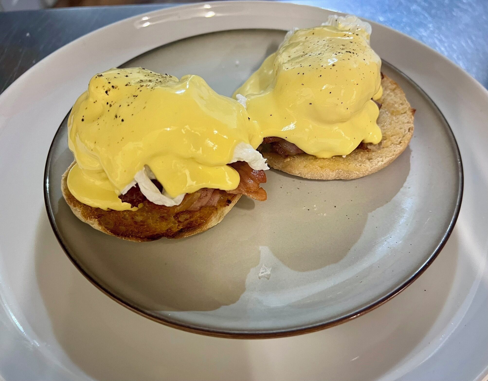 Two eggs benedict sandwiches on a plate.