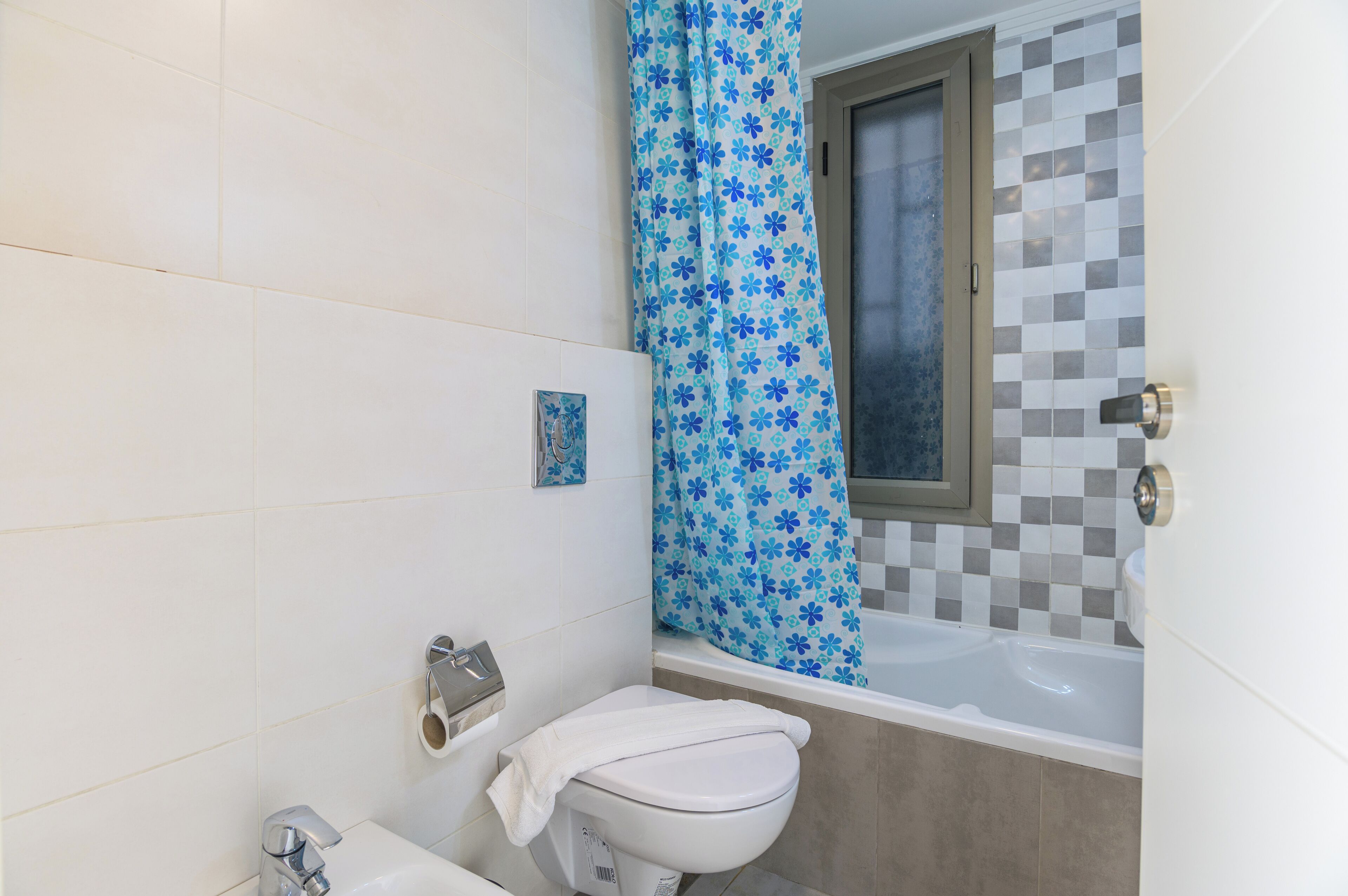 A bathroom with a toilet, sink, and bathtub.