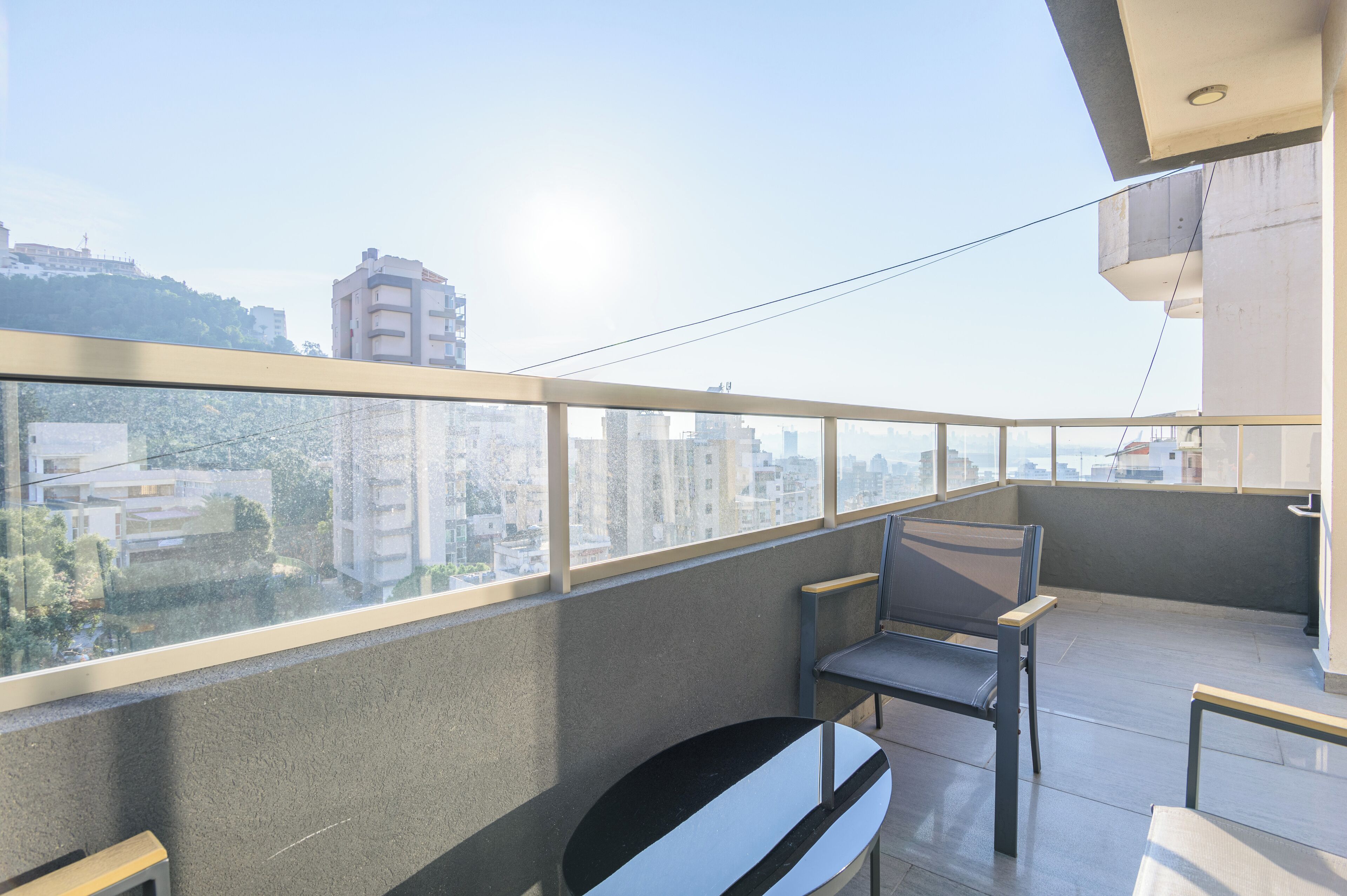 Ein Balkon mit Blick auf die Stadt, einem Tisch und zwei Stühlen.