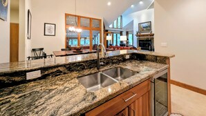 A kitchen with granite countertops, stainless steel sink, and wooden cabinets. - Slopeside Condo w/ Private Hot Tub – Steps to Peru Lift & Ski School (Keystone)