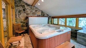 A hot tub in a room with stone walls, wooden beams, and a bench. - Slopeside Condo w/ Private Hot Tub – Steps to Peru Lift & Ski School (Keystone)
