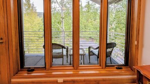 A room with a large sliding glass door leading to a balcony with outdoor furniture. - Slopeside Condo w/ Private Hot Tub – Steps to Peru Lift & Ski School (Keystone)