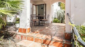 A covered patio area with a table and chairs, surrounded by plants and a view of the garden. - Serene Private Suite Patio ~ Upscale Berkeley (Berkeley)
