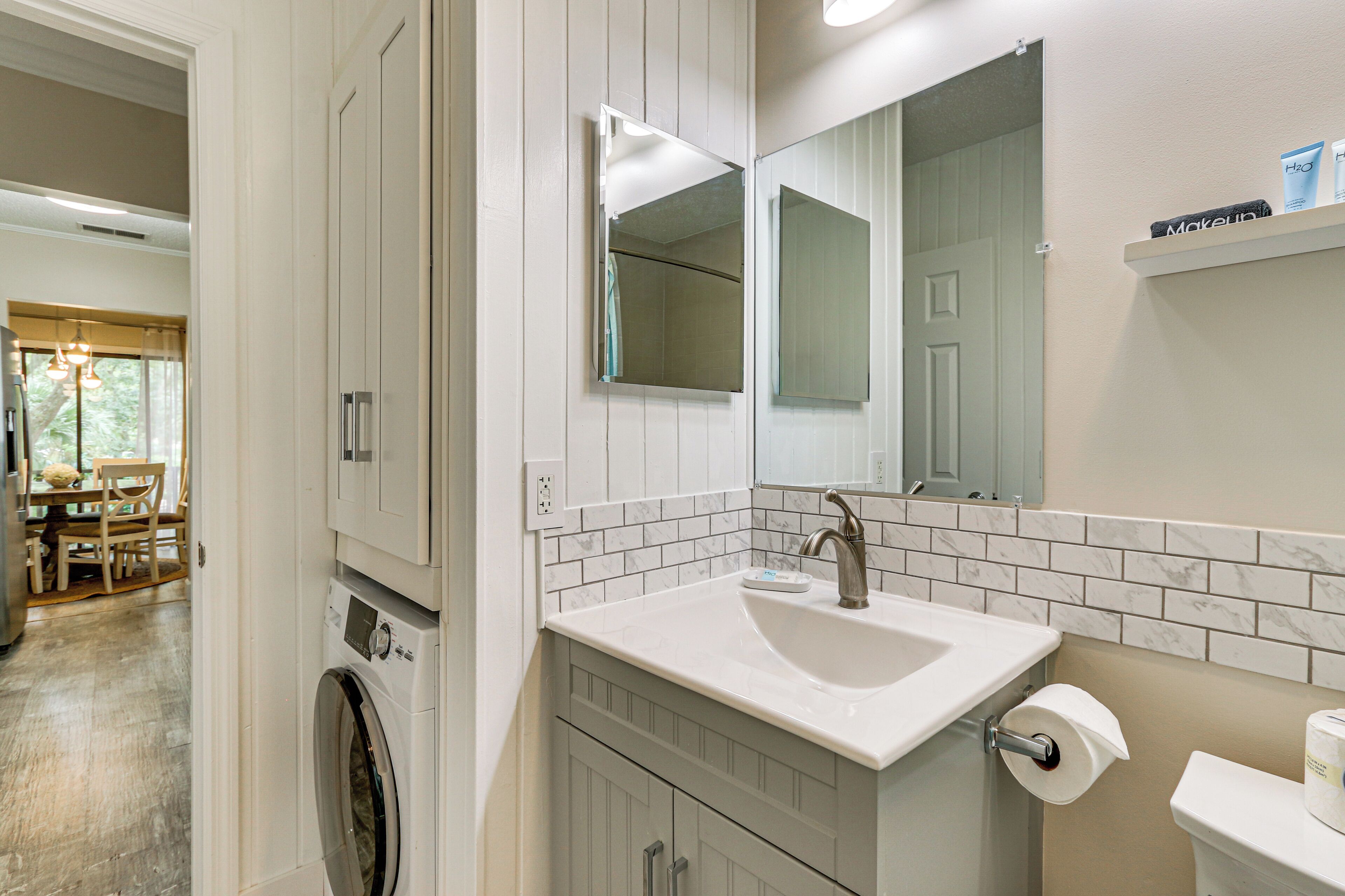 A bathroom with a sink, mirror, and a toilet.