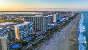 Un paisaje urbano costero con rascacielos, una playa y cielo despejado.