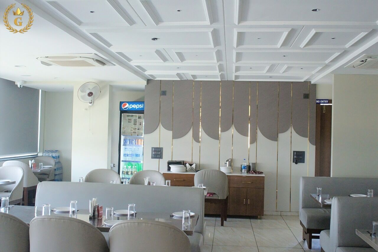 A restaurant with a modern interior, including a Pepsi refrigerator, a fan, and a no entry sign.