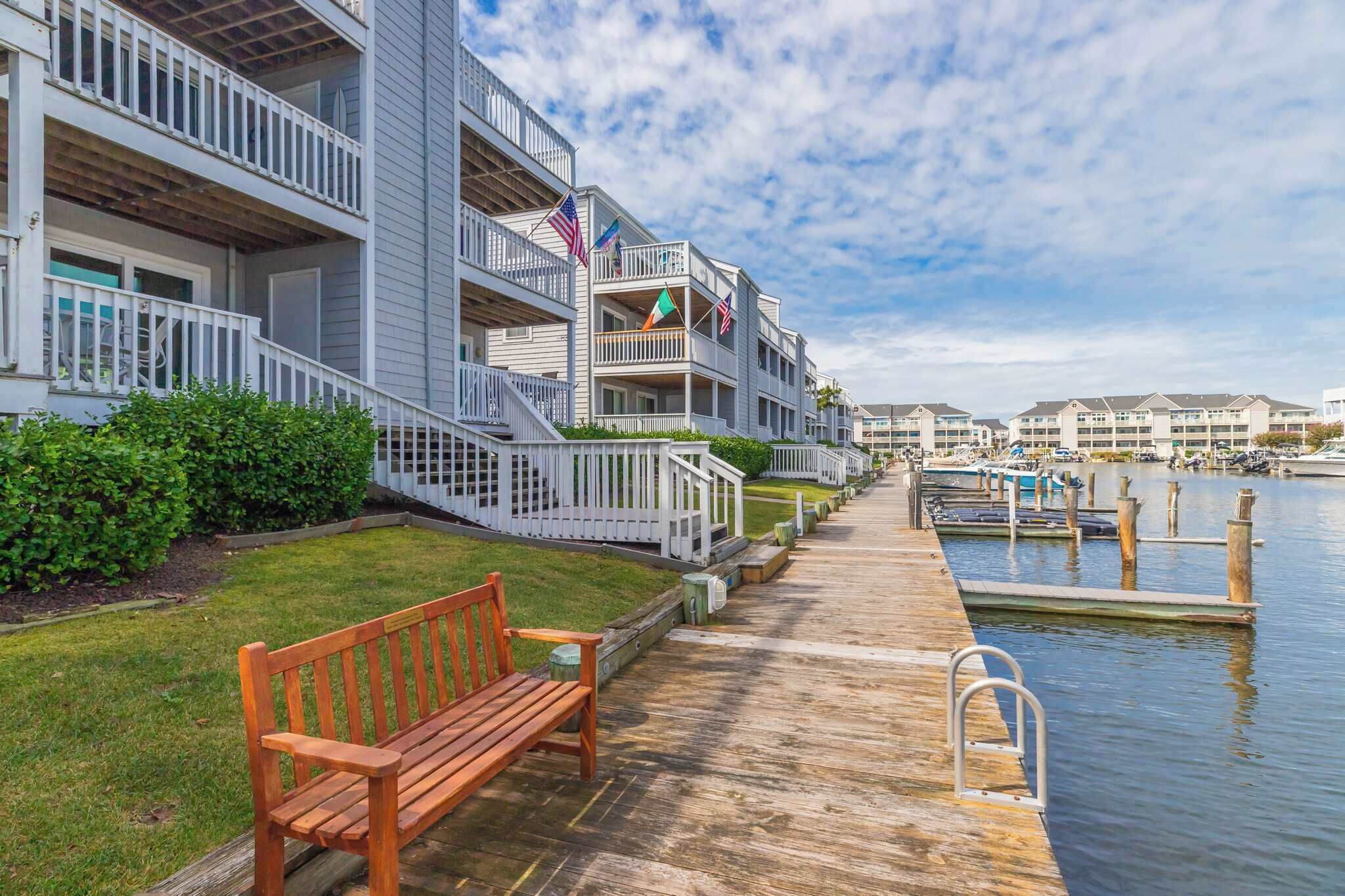A waterfront hotel with balconies, a wooden deck, and a marina.