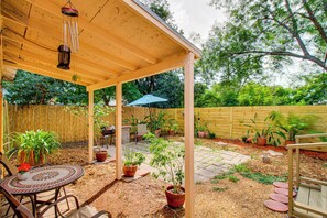 A covered patio area with a wooden ceiling, a round table with chairs, potted plants, and a small garden with stepping stones. - 4 Mi to Mcgee Beach: Corpus Christi Home w/ Patio (Corpus Christi)