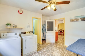 A laundry room with a washing machine, dryer, and a ceiling fan. There is a clock on the wall and a door leading to another room. - 4 Mi to Mcgee Beach: Corpus Christi Home w/ Patio (Corpus Christi)