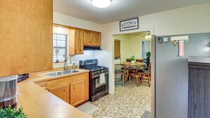 A kitchen with wooden cabinets, a stove, and a sink.