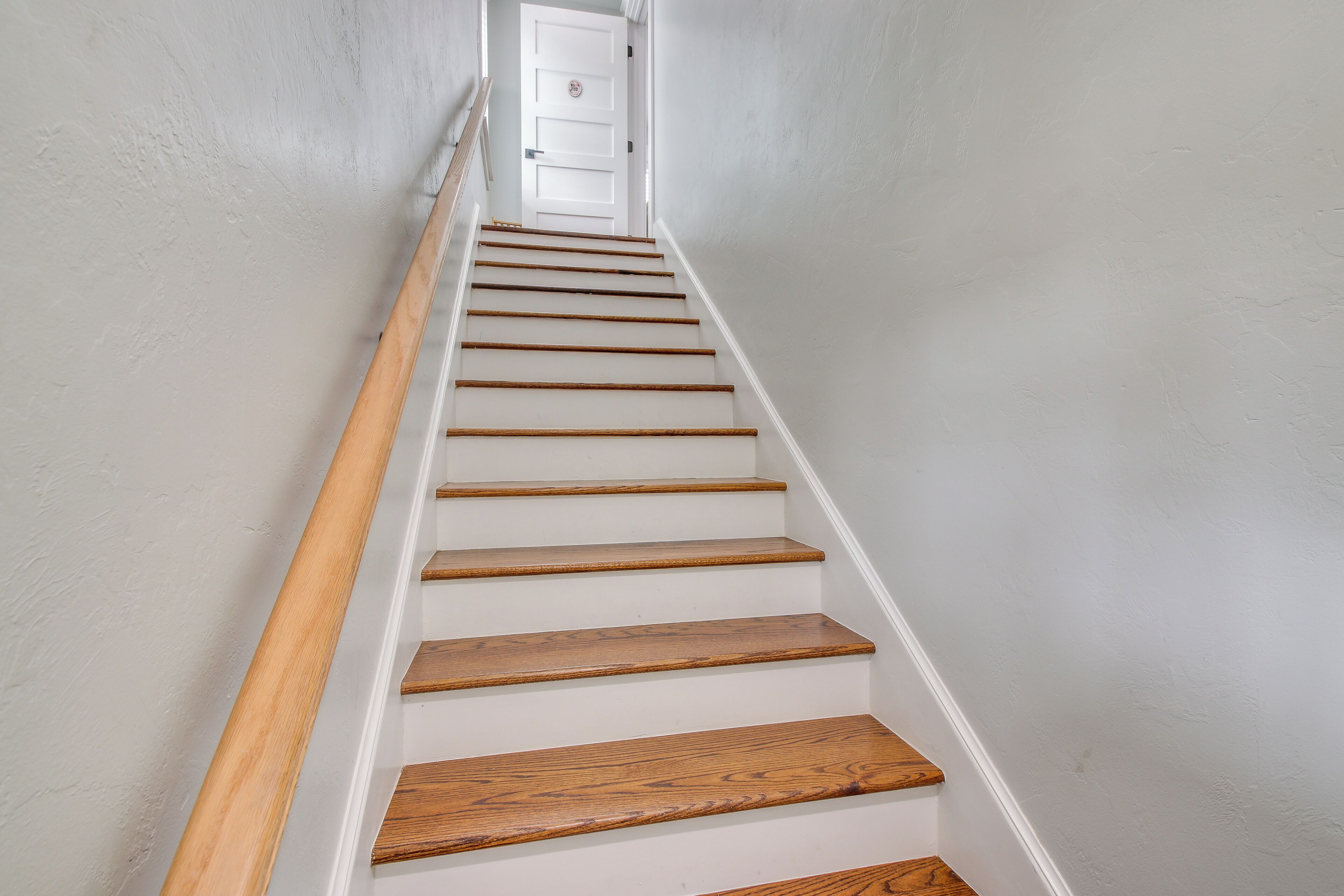 Eine Treppe mit Holzboden und weißen Wänden.