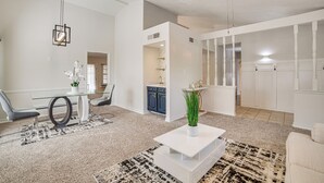 A modern living room with a glass dining table, a white coffee table, and a ceiling fan. - Fenced-in Yard: Home < 1 Mi to Lake Ray Hubbard! (Garland)