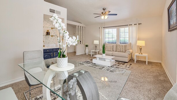 A modern living room with a glass dining table, a sofa, a coffee table, and a ceiling fan. - Fenced-in Yard: Home < 1 Mi to Lake Ray Hubbard! (Garland)