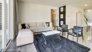Ein modernes Wohnzimmer mit einer Couch, einem Couchtisch und Sesseln.
