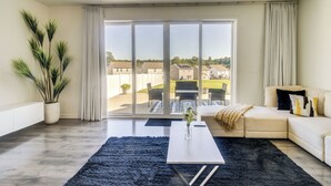 Ein modernes Wohnzimmer mit einem großen Schiebeglasfenster, das auf eine Außenpatio führt.