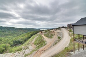 Un chantier de construction avec un chemin de terre, une cabane en bois et un bâtiment doté d’un balcon.