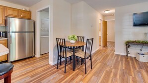 A modern kitchen with a stainless steel refrigerator, wooden cabinets, and a dining area with a round table and chairs. - 16 Mi to Lake Sara Beach - Pet-friendly Home (Montrose)