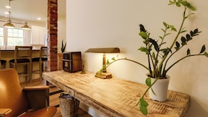 A kitchen with a brick column, wooden chairs, a table with a lamp, and a potted plant. - 1 Block to Loveland Bike Trail: 'the Frog Man Inn' (Loveland)