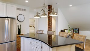A modern kitchen with a central island, stainless steel appliances, and a hanging light fixture. - 1 Block to Loveland Bike Trail: 'the Frog Man Inn' (Loveland)
