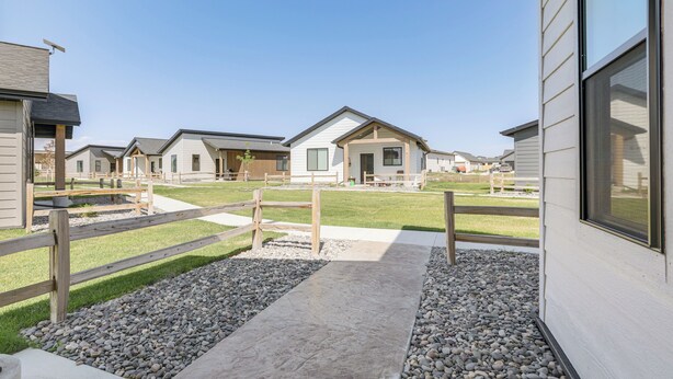 Zona residencial con varias casas, un sendero de grava y una valla de madera.