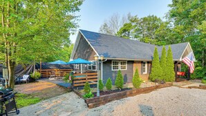 A rustic cabin with a stone patio, wooden deck, and a small garden area. - Otter Creek Rec Area On-site! Serene Family Home (Brandenburg)