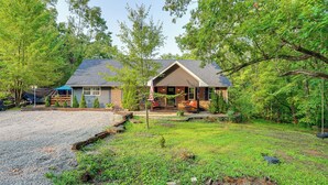 A two-story house with a covered porch, surrounded by a grassy yard and trees. - Otter Creek Rec Area On-site! Serene Family Home (Brandenburg)