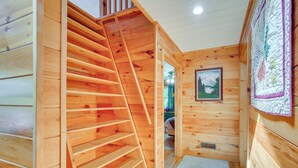 Ein Holzinnenraum mit einer Wendeltreppe, einem gerahmten Bild an der Wand und einer Wanddecke.