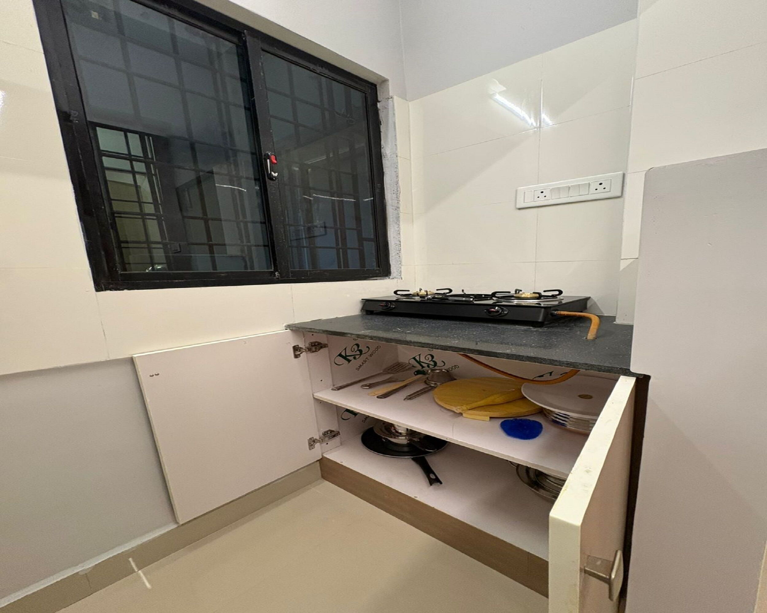 A small kitchen with a window, a gas stove, and a countertop with kitchen utensils.