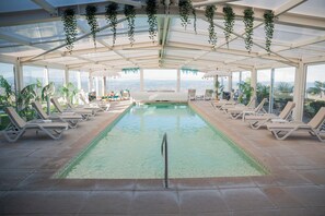 Una piscina cubierta, tumbonas