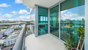 Een hoog appartementencomplex met grote ramen van vloer tot plafond, met uitzicht over de stad.