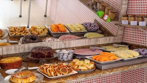Un bufé con diversos alimentos, incluyendo pasteles, panes y frutas.