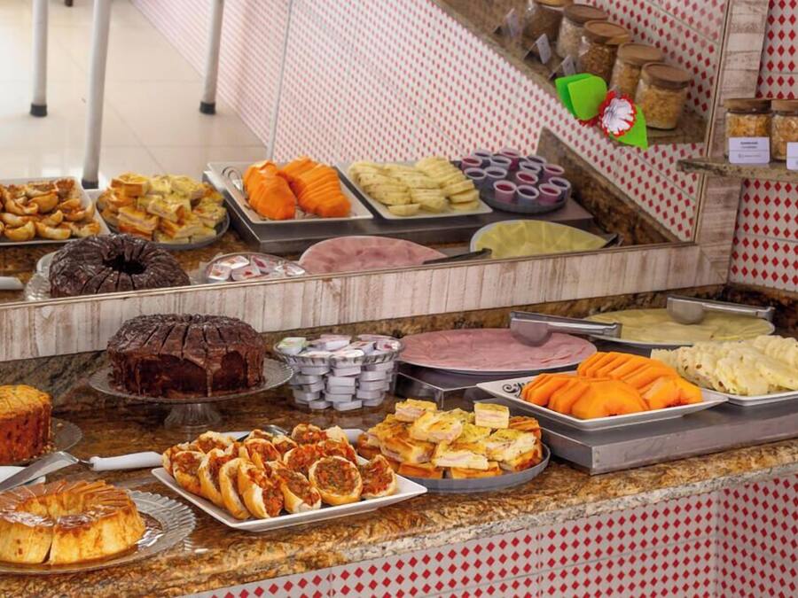 A buffet with various food items including cakes, pastries, and fruits.