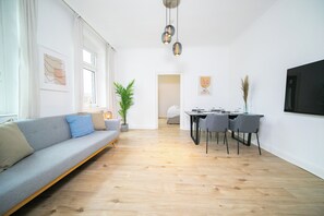 Departamento Deluxe, 1 cama Queen size y sofá cama, cocineta | Área de sala de estar | Smart TV de 55 pulgadas con canales por cable