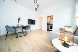 Departamento Deluxe, 1 cama Queen size y sofá cama, cocineta | Área de sala de estar | Smart TV de 55 pulgadas con canales por cable