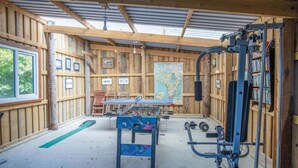 Une pièce en bois avec un baby-foot, une carte et du matériel d’exercice.