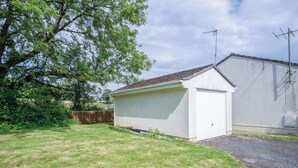 A small white garage with a sloped roof, adjacent to a larger building with a flat roof. - Clover Cottage - 2 Bedroom Cottage - Begelly (Kilgetty)