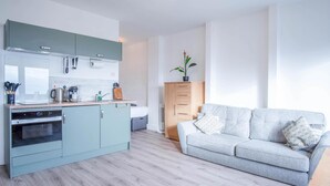 A modern kitchen with a built-in oven and a dining area with a wooden table and chairs.