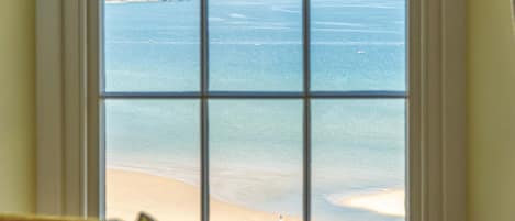 Una ventana con vista a una playa y acantilados.