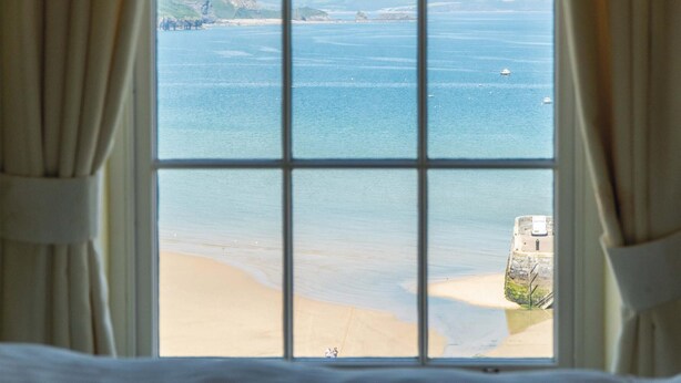 A window with a view of a beach and cliffs. - 5 Belle Vue Court - 2 Bedroom Apartment - Tenby (Tenby)
