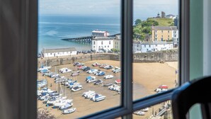 A coastal town with a pier, boats, and buildings along the shore. - 5 Belle Vue Court - 2 Bedroom Apartment - Tenby (Tenby)