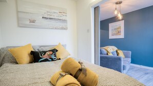 A hotel room with a bed, a sofa, and a painting on the wall.